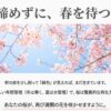澄んだ青空を背景にした満開の桜の風景と、「諦めずに、春を待つ。」というメッセージ