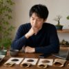 盆栽用の種や鉢を並べて購入先を検討する日本人男性