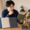 盆栽初心者が入門書を比較しながら育て方を学ぶ様子