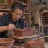 陶芸工房で盆栽鉢を手作業で仕上げる日本人の陶工